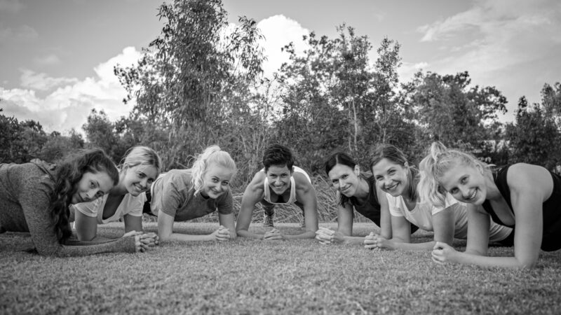grayscale photo of children on grass field